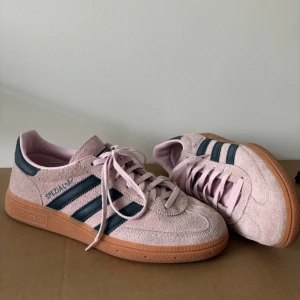 Adidas Spezial sneakers i rosa mocka - Säljer ett par superfina Adidas Spezial  i ljusrosa med mörkblå ränder. Skorna är väldigt varsamt använda, max 5 gånger. Storlek 40 2/3. 
