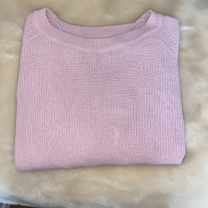 Ljusrosa stickad tröja Vero Moda - Superfin ljusrosa stickad tröja från Vero Moda. Tröjan har rund halsringning, ribbade muddar och är långärmad. Perfekt för lager på lager och passar till både jeans och kjol. Enkel och stilren design som är lätt att matcha. Tröjan har en liten fläck längst ut på armen.