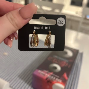 Guld- och silverfärgade örhängen Montini - Snygga chunky örhängen från Montini i både guld- och silverfärg. De har en cool, droppformad design som ger en modern och trendig vibe. Perfekta för att lyfta vilken outfit som helst med lite extra bling. Helt nya, aldrig provade.