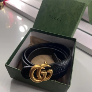Svart Gucci bälte - Svart Gucci bälte ej äkta, aldrig använd, packet box med följer. Går att vända från svart till brun. 