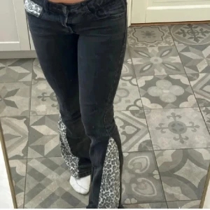 Svarta leopard jeans Lågmidjade  - Ett par lågmidjade svarta jeans me leopard mönster. Storlek 36 eller 38. Men det finns lite slitningar nere vid fötterna!! 