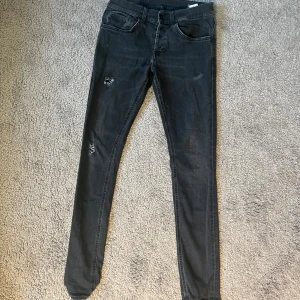 Svarta Dondup jeans med slitningar - Säljer ett par svarta Dondup jeans med slitningar. Bra skick