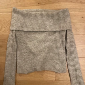 Ljusgrå offshoulder stickad topp H&M - Supermysig ljusgrå stickad topp från H&M med bred offshoulder-krage. Ribbad struktur och långa ärmar ger en chill vibe. Perfekt att styla med jeans eller kjol för en trendig look. Snygg passform som sitter bekvämt över axlarna. Priset går att buda på🥰 även fast storleken är L så sitter den fint med en liten oversize look för någon som vanligtvis har XS-S