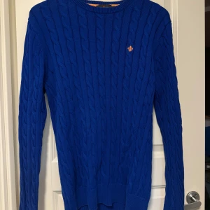 Kabelstickad blå tröja från Morris - Snygg kabelstickad tröja från Morris i klarblå färg. Tröjan är gjord i 100% pima bomull. 