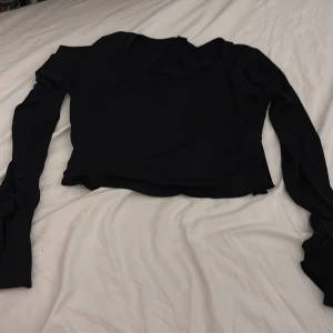 Svart långärmad topp från SHEIN - Svart långärmad topp från SHEIN i storlek L. Modellen är enkel med rund hals och har en croppad passform. Materialet känns mjukt och lätt, perfekt för att styla med jeans eller kjol. Snygg basic som funkar till många looks.