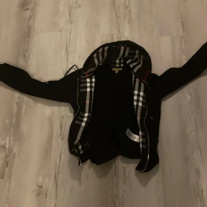 Svart burberry hoodie - Svart burberry hoodie nästan helt oanvänd om du vill ha fler eller bättre bilder skickar jag med glädje!