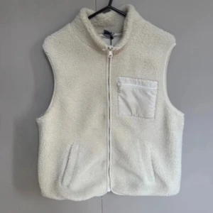 Vit fleeceväst med dragkedja - Mysig vit fleeceväst med hög krage och hel dragkedja framtill.  Från Lindex 