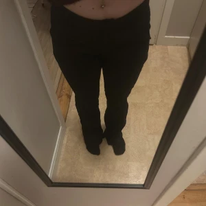 Svarta linne kostym byxor med låg midja - Säljer ett par svarta byxor med bootcut-snitt och låg midja. De har en klassisk look med raka ben som blir lite vidare nedtill. Perfekta för dig som gillar en stilren och enkel vibe. Passar till sneakers eller boots.