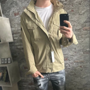 NY J.lindeberg Bailey Field Jacket - Nytt skick, inga defekter och tags medföljer. Storlek L passar också M, passar dig som är mellan 180-190cm ungefär. Nypris ca 4000kr. Modellen är 185 cm, 79 kg. Passar bra nu till vintern. Skriv för mer information!🤝