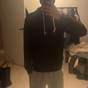 Svart hoodie från Pier One - Svart hoodie från Pier One med vita snören i huvan. Klassisk modell med lång ärm och normal passform. Perfekt för chill dagar eller när du vill ha en enkel och stilren look. Mjuk och skön bomullskänsla. Passar mig som är 174 väger 58kg.