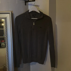 Mörkgrå merinoulltröja J.Lindeberg - Säljer denna half zip tröjan från J.lindberg. Denna tröja är i god skick och passar väldigt bra till de sista dagarna av golf spelen men går också att styla väldigt bra till daglig användning, tröjan är dessutom i 100% merino ull. Tröjan är ganska slim fit och greppar över hela kroppen även vid midjan. Ny pris 1500. 