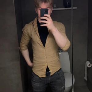 Beige linneskjorta Polo Ralph Lauren - Slim fit skjorta i beige linne från Polo Ralph Lauren. Klassisk krage, långa ärmar och knappar framtill. Snygg passform som sitter tajt mot kroppen och passar perfekt till jeans. Stilren och enkel design utan mönster. Säljer för den är för liten på 180 cm, 80 kg. Använd fåtal gånger( under 5)