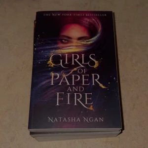 Girls of Paper and Fire - En New York Times-bästsäljare med ett magiskt omslag och lockande titel. Perfekt för dig som gillar spännande och fantasifulla berättelser. Boken passar unga vuxna som vill försvinna in i en annan värld.