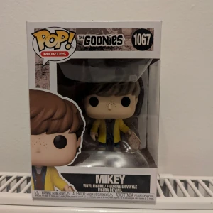 Funko Pop! Movies The Goonies Mikey #1067 - Samlingsfigur från Funko Pop! Movies-serien, The Goonies Mikey #1067. Figuren är i nyskick och levereras i originalförpackning, perfekt för samlare eller fans av filmen. Inga synliga skador på kartongen eller figuren.