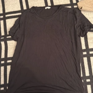 Svart t-shirt från Filippa K, S - En stilren svart t-shirt från Filippa K i storlek S. T-shirten har rund hals och korta ärmar, tillverkad i mjuk bomull som känns skön mot huden. Perfekt för dig som gillar minimalistisk och clean look.