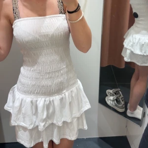 Vit kort volangklänning med spetsband - Vit tube top klänning från Gina använd cirka 2 gånger o är i nutt skick🤍 pris kan alltid diskuteras