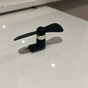 Mini fläkt med Lightning-kontakt - Praktisk mini fläkt som ansluts direkt till din iPhone via Lightning-kontakt. Perfekt för svalka på språng. Fläkten är kompakt, lätt och i gott skick utan synligt slitage. Passar alla iPhones med Lightning-port. Enkel att använda och ta med sig.