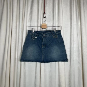 Blå jeanskjol - Mått: Ytterbensmått 33 cm     Midjemått (mätt rakt över) 36 Cm  Grenmått 13 cm                                                               Bra skick. Hör gärna av er vid frågor!                    Följ oss : Instagram a_wearuf                                                         TikTok : awearuf                                                                   (Nr 22 ) 