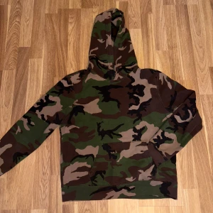 Polo Ralph Lauren Camoflauge Hoodie - !!PASSAR STORLEK XS-S!! - Säljer en grym hoodie från Polo Ralph Lauren i storlek XL med klassiskt camouflage-mönster i grönt, brunt och beige. Tröjan har huva, lång ärm och en stor magficka framtill. Perfekt för dig som gillar streetwear och vill sticka ut med en cool look.