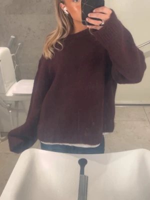 Stickad tröja  - Vinröd stickad tröja med rund halsringning och långa ärmar. 