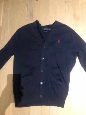 Cardigan från Ralph lauren - Säljer nu min ralph lauren Cardigan då en inte passade mig. | Tröjan passar perfekt nu till hösten. | Otroligt skönt material. | OBS! Det är ett pytte litet hål i vänstra armen. Syns inte när man använder den.| Storlek XS