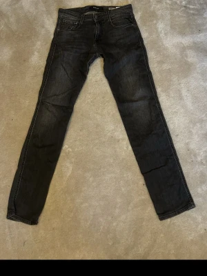 Svarta Replay jeans anbass  - Snygga svarta jeans från Replay i modellen Anbass, strl 30/32. De är i fint skick och de finns inga speciella defekter på byxorna. Hör av er vid frågor, priset kan diskuteras. 