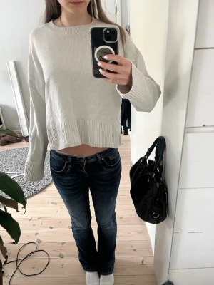 Stickad tröja från &Other Stories  - Vit stickad tröja från &Other Stories med avslappnad passform och breda ribbade muddar vid ärmslut och nederkant. Tröjan har rund halsringning och är lite croppad. Ganska använd med fortfarande i bra skick💞