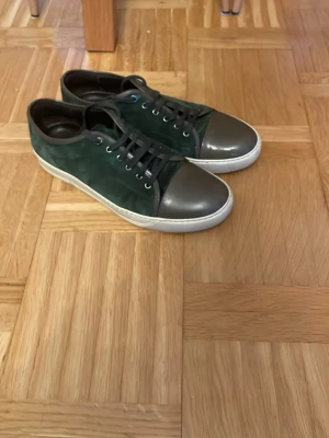 Gröna Lanvins - Snygga gröna lanvins med ovandel i mocka och tåparti i blankt material. Skorna har vita sulor och gröna snören. Perfekta för dig som vill ha en stilren men unik look. Kontakta mig vid minsta lilla fråga! Priset kan diskuteras vid snabb affär!