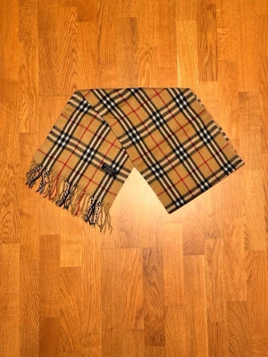 Beige Burberry halsduk - Säljer en beige halsduk från Buberry. Halsduken är gjord i 100% lamull och är i fint skick. Var inte rädd för några frågor. Pris diskuteras inte!
