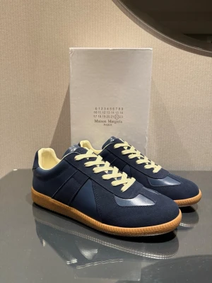 Maison margiela skor - Säljer dessa feta Maison margiela skorna i en mörkblå färg. Skorna är i storlek 43 och har bara testats inomhus. Perfekta skor nu till våren. Vid frågor eller funderingar är det bara att höra av sig‼️