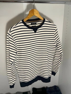 Randig tröja från Massimo Dutti - Snygg långärmad tröja från Massimo Dutti med marinblå och vita horisontella ränder. Den är Strl S