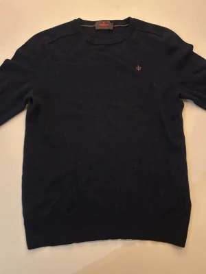 Mörkblå stickad tröja från Morris - Mörkblå stickad tröja från Morris i 100% merinoull. Klassisk rund halsringning och diskret logga broderad på bröstet. Perfekt för dig som gillar stilrena och tidlösa plagg med hög komfort. Tröjan sitter som en S och är i bra skick. Köpte tröjan för 2600 kr. Bara att höra av sig vid frågor😃pris kan diskuteras 