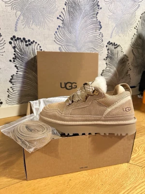 Ugg Lowmel Sand 39 - Snygga beige kängor från UGG LOWMEL SAND 39 i mocka med grov platt sula och rund tå. Skorna har snörning med rejäla öglor och fluffig vit insida i fårskinn. Perfekta för dig som vill ha både stil och komfort. Extra skosnören medföljer. Kvitto finns❤️