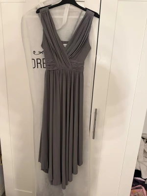 Grå långklänning från Bubbleroom  - Lång klänning köpt från Bubbleroom och är i nyskick då jag endast har använt den 1 gång.