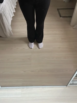 Svarta bootcut leggings - Säljer ett par svarta leggings med bootcut-modell och hög midja. De är stretchiga och sitter tight upptill men släpper ut vid bensluten för en snygg siluett. Perfekta till både stickad tröja eller crop top. Materialet känns mjukt och följsamt.