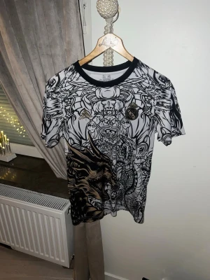 Real Madrid fotbollströja - Säljer sen real Madrid t shirt med mönster, jätte bra skicka och pris diskuteras vid snabb äffär. Storlek S men passar M bra
