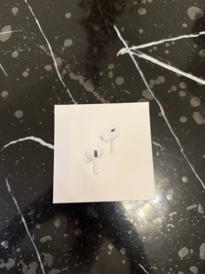 Apple AirPods Pro 2nd Gen - Säljer ett par vita Apple AirPods Pro (2nd generation) i originalförpackning. Trådlösa in-ear hörlurar med stilren design och kompakt laddningsetui. Perfekta för musik, poddar och samtal med grymt ljud och brusreducering.