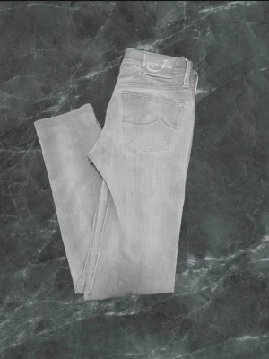 Jacob Cohen jeans - Säljer ett par ljusgrå jeans från Jacob cohen med klassisk femficksdesign och ganska slim ben. Perfekta för dig som gillar en clean och enkel stil.