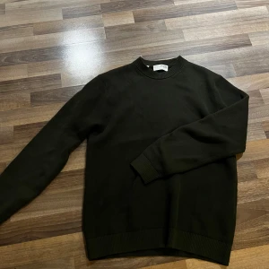 Mörkgrön stickad tröja - Säljer en stilren mörkgrön stickad tröja med rundad hals. Perfekt för lager-på-lager och enkel att matcha med olika outfits. Tröjan är från Selected Homme och är använd fåtal gånger. Storlek M. Priset går att diskutera👍