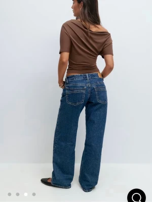 Blåa lågmidjade jeans - Super snygga blåa jeans! De är vida och väldigt lågmidjade! Aldrig använda och slutsålda på hemsidan!