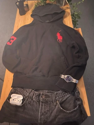 Svart Ralph Lauren hoodie - Säljer min schyssta hoodie från Polo Ralph Lauren. Tillverkad i mjukt bomullsmaterial som är skönt att bära. | ca 45 cm axelbredd, ca 61cm från axeln till midjan!  |Skriv vid frågor 🥂