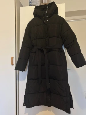 Svart lång dunjacka med huva - Trendig jacka från nelly. Numera slutsåld. Liten  defekt som ej påverkar funktionen eller syns 