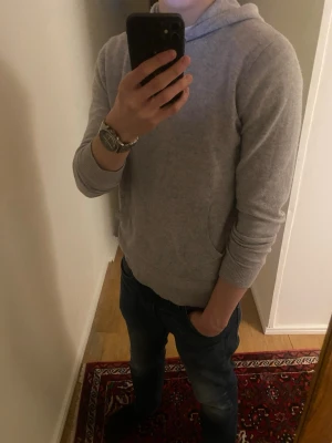 Ljusgrå kashmir hoodie - Säljer en stilren ljusgrå kashmirblend hoodie från Riley. Hoodien har en klassisk huva med dragsko och en stor magficka framtill. Kashmiret i den bidrar till ett oerhört mjukt och bekvämt material. Den har inga defekter alls 😁Priset är inte hugget i sten 🔨🪨