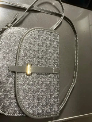  axelväska  - Snygg grå axelväska, med klassiskt mönster, helt ny och oanvänd, skickas inom 24 timmar