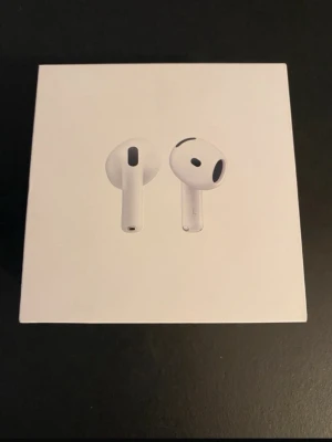 Apple AirPods 4 trådlösa hörlurar - Säljer ett par vita Apple AirPods 4 med laddningsetui. Hörlurarna är trådlösa och kompatibla med USB-C-laddare. Snygg och stilren design i plast, perfekt för dig som vill ha smidiga hörlurar till mobilen eller datorn.