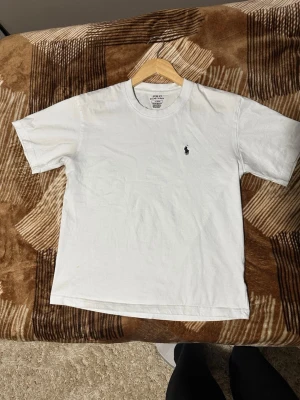 Vit t-shirt från Polo Ralph Lauren - Klassisk vit t-shirt från Polo Ralph Lauren i bomull. Stilren använt fåtal gånger inga prickar eller märke av användning. 