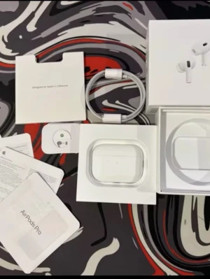 AirPods Pro gen 2 - Apple AirPods Pro trådlösa hörlurar med aktiv brusreducering, laddningsetui och originaltillbehör. Produkten ser ut att vara i gott skick med komplett förpackning, laddkabel och manualer. Perfekt för musik, samtal och träning.