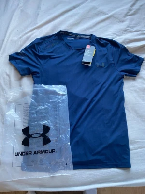 Under armor compression shirt - Fick denna i julklapp men den passade inte och inget kvitto finns kvar.  aldrig använd, lappar sitter kvar på, du får med dustbagen! Skriv om du har funderingar!😉😉😀