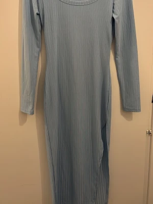 Ljusblå långärmad ribbad klänning SHEIN - Säljer en ljusblå långklänning från SHEIN i storlek Xs. Klänningen har ett ribbat mönster, rund halsringning och långa ärmar. Materialet är mjukt och stretchigt, vilket gör den bekväm att bära. Perfekt för dig som gillar enkel och stilren design.