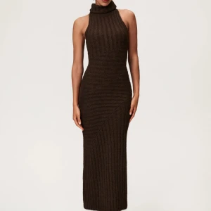 Adoore Brun stickad lång klänning  - Säljer en brun lång stickad klänning med ribbad struktur och polokrage. Klänningen är ärmlös och har en figurnära passform som framhäver siluetten. Kan stylas med bälte för extra detalj. Från Adoore i storlek 34. Alltid använd endast testad!